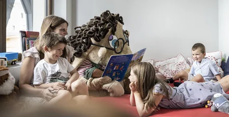 The best references for our hotel marketing Children listen to a person in a large mascot costume reading a book