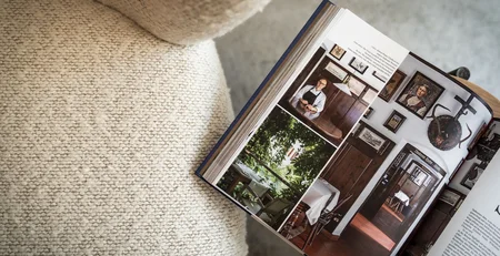 The best references for our hotel marketing Open book showing photos of a man and interiors on a sofa