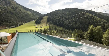The best references for our hotel marketing Infinity pool overlooking green forested mountains and blue sky