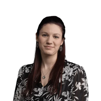 Johanna Mair | Visual Communication Designer Porträt einer lächelnden Frau mit langen Haaren und floraler Bluse vor weißem Hintergrund