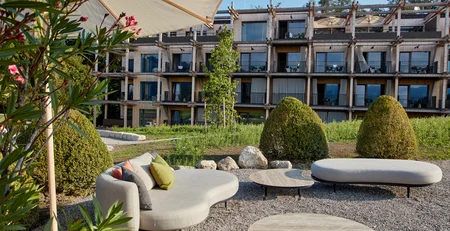 The best references for our hotel marketing Modern outdoor seating area with furniture in front of wooden building in sunlight