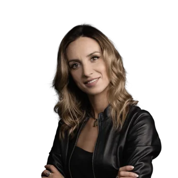 Elisabetta Rossi | Senior Consultant Frau mit lockigem Haar in Lederjacke vor weißem Hintergrund
