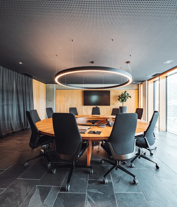 Seminarraum in Südtirol zum Mieten gesucht? Der Brandnamic Campus ist ideal Moderner Konferenzraum mit rundem Holztisch und schwarzen Bürostühlen