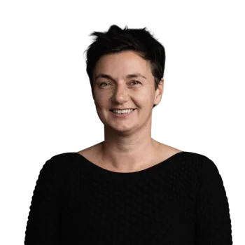 Bettina Conci | Head of Corporate Marketing Portrait einer lächelnden Frau mit kurzen schwarzen Haaren im schwarzen Pullover