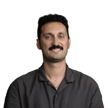 Marco De Crescenzo | Search Engine Advertiser Porträt eines lächelnden Mannes mit dunklem Hemd und Schnurrbart vor weißem Hintergrund