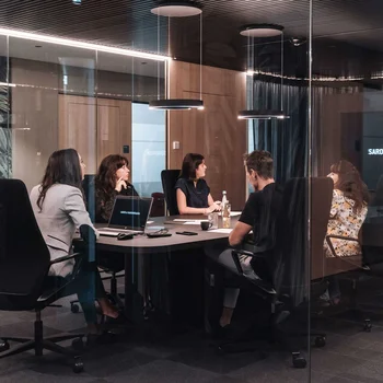 Seminarraum in Südtirol zum Mieten gesucht? Der Brandnamic Campus ist ideal Menschen sitzen in einem modernen Besprechungsraum mit Glaswänden