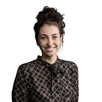 Heidi Sulzenbacher | Head of Customer Success Management Junge Frau lächelt, trägt schwarz gemustertes Hemd vor weißem Hintergrund