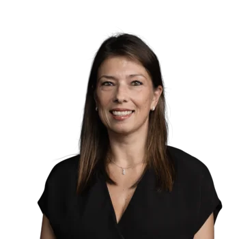 Lavinia Turi | Sales Consultant Frau mit braunen Haaren lächelt, schwarzes Oberteil und Halskette vor weißem Hintergrund