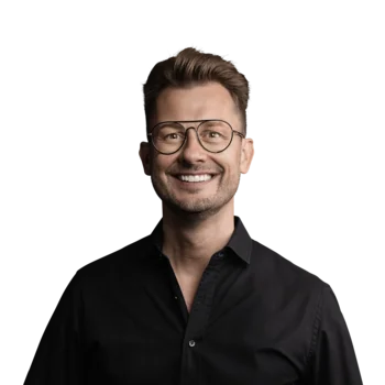 The best references for our hotel marketing Man wearing glasses and black shirt smiling against white background