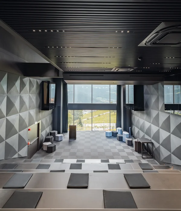 Seminarraum in Südtirol zum Mieten gesucht? Der Brandnamic Campus ist ideal Moderner Hörsaal mit geometrischen Wandmustern und großen Fenstern