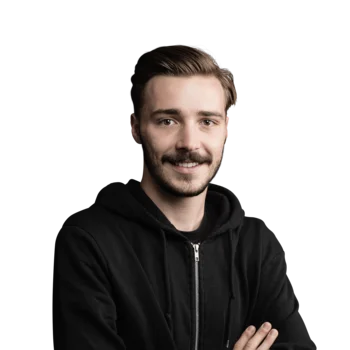 Niklas Kemenater | Search Engine Advertiser Junger Mann mit Bart und schwarzer Kapuzenjacke lächelt