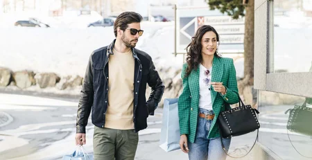 The best references for our hotel marketing Couple walking with shopping bags in winter setting