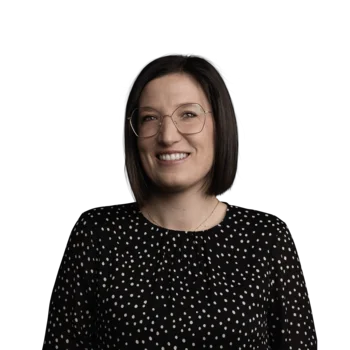 Evi Valentin | Senior Cooperation Groups Manager Frau mit schwarzer Brille und gepunktetem Oberteil lächelt