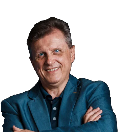 Brandnamic: Hotellösungen von Hospitality-Experten Porträt eines lächelnden Mannes in blauem Anzug vor schwarzem Hintergrund