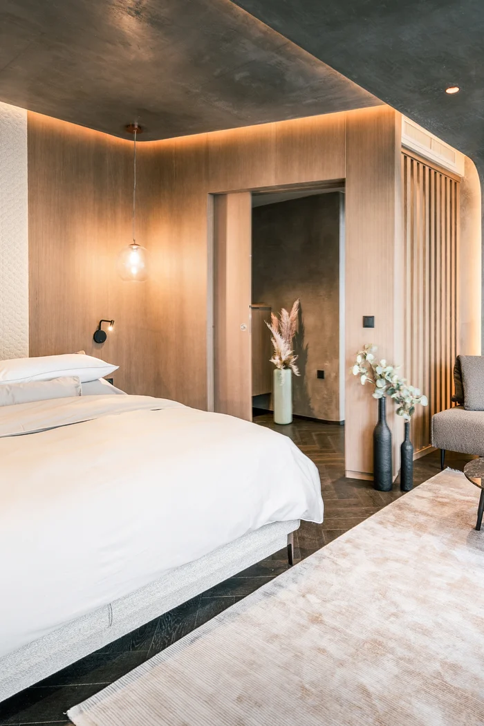 Brandnamic: Hotellösungen von Hospitality-Experten Modernes Schlafzimmer mit Holzpaneelen, Bett und Sitzecke