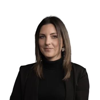 Sarah Hofer | Media Planner Porträt einer jungen Frau mit schwarzen Jacke und langen braunen Haaren