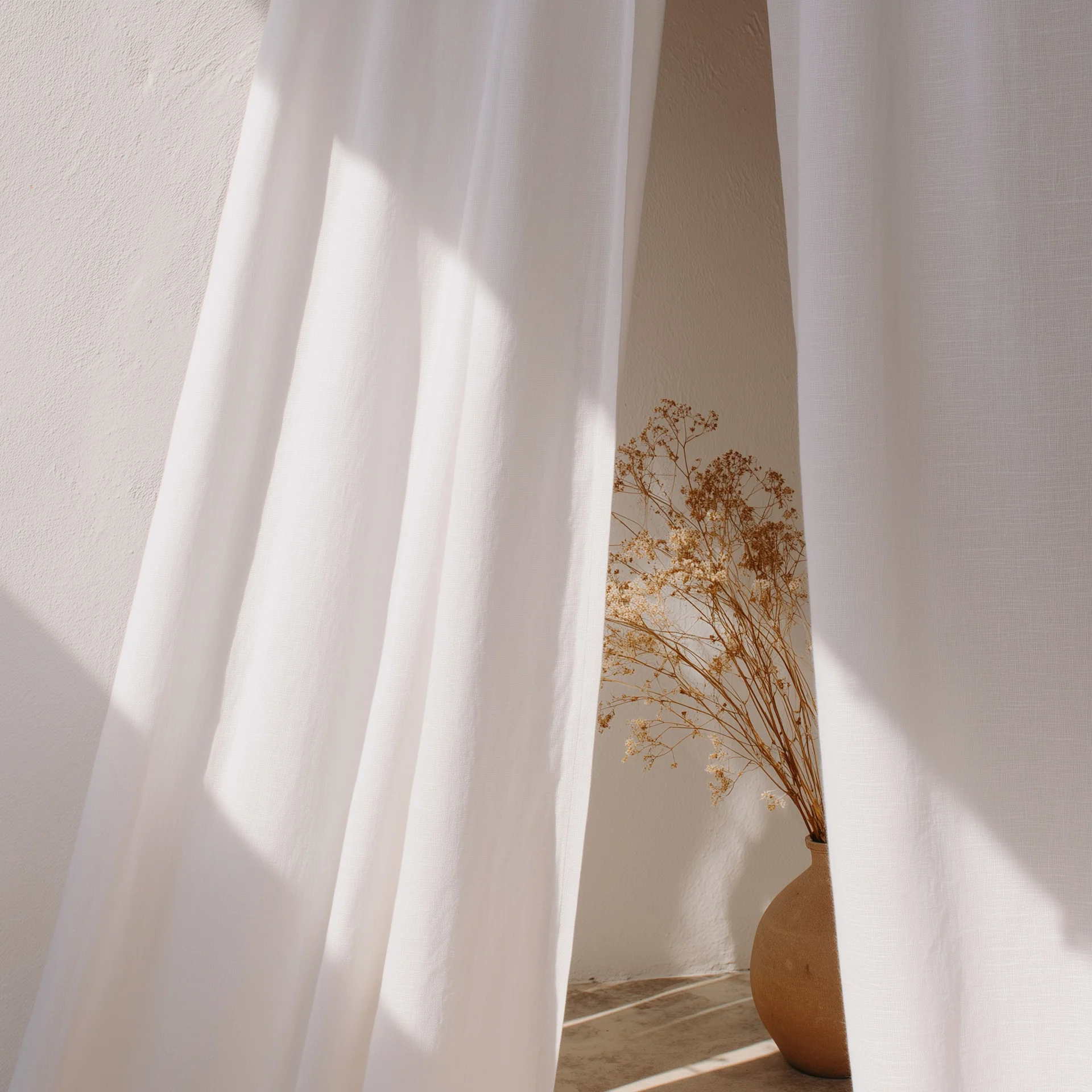 Die Kooperationen unserer Marketingagentur Getrocknete Blumen in Vase hinter weißen Vorhängen im Sonnenlicht