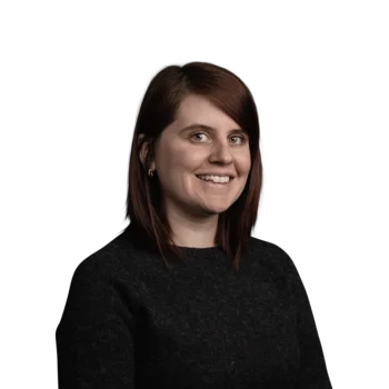 Verena Bacher | Senior Visual Communication Designer Porträt einer lächelnden Frau mit roten Haaren und schwarzem Pullover