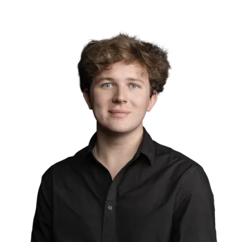 Maximilian Hütter | Web Developer Porträt eines jungen Mannes mit lockigem braunem Haar und schwarzem Hemd