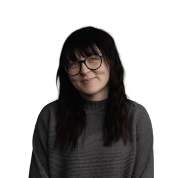 Luana Dallapiccola | Senior Customer Success Manager Frau mit langen dunklen Haaren, Brille und grauem Pullover lächelt freundlich