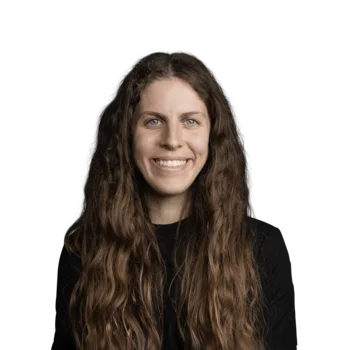 Verena Delponte | Junior Media Planner Porträt einer lächelnden Frau mit langen, lockigen Haaren und schwarzem Oberteil