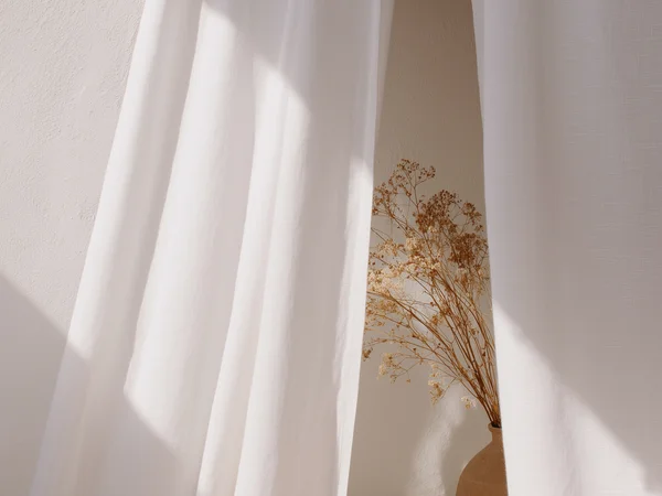 Hotelberatung: Experten für die Hospitalitybranche Trockenblumen in Vase hinter weißen Vorhängen mit Sonnenlicht
