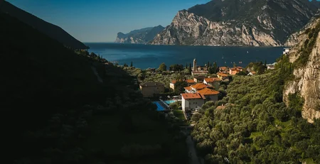 The best references for our hotel marketing Village by lakeside surrounded by mountains and green forest under clear sky