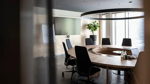 Brandnamic: Hotellösungen von Hospitality-Experten Runder Besprechungstisch mit schwarzen Stühlen und großem Monitor an der Wand