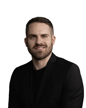 Hannes Heidegger | Senior Consultant Porträt eines lächelnden Mannes mit Bart in schwarzem Anzug vor weißem Hintergrund