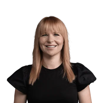 Martina Stampfl | Hairstylist Styling Nook Porträt einer lächelnden Frau mit roten Haaren und schwarzem Oberteil