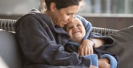 The best references for our hotel marketing Mother and child warmly embracing on the sofa at home