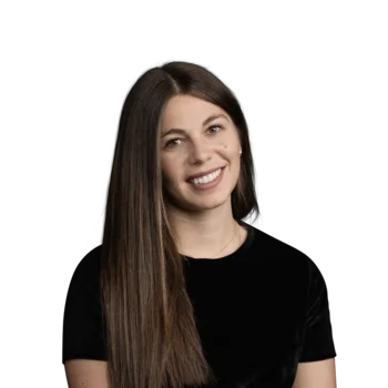 Julia Kallweit | Senior Media Planner Junge Frau mit langen braunen Haaren lächelnd in schwarzem Oberteil