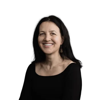 Alexandra Fössinger | Corporate Communication Director Lächelnde Frau mit schwarzem Oberteil vor weißem Hintergrund