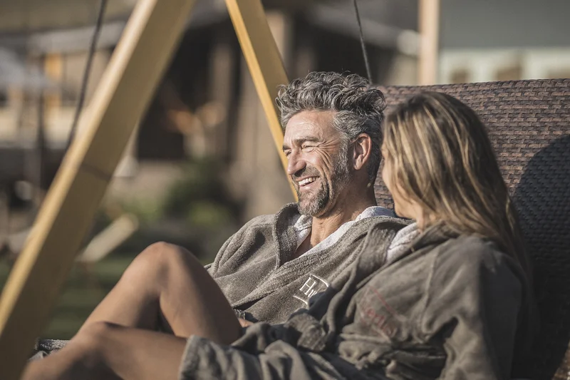 Eine Website mit Stil – made by Brandnamic Paar entspannt sich gemeinsam auf einer Außenschaukel in Freizeitkleidung