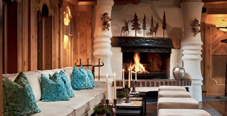 The best references for our hotel marketing Cozy room with fireplace, sofa, candles, and warm wooden decor