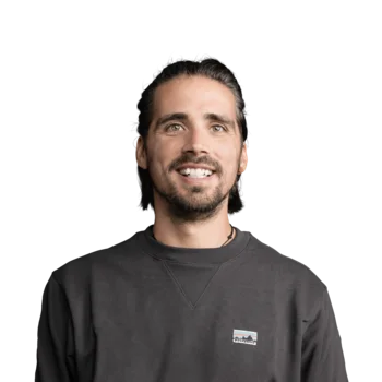 Robin Oberhollenzer | Head of Web Development Lächelnder Mann mit dunklem Pullover vor weißem Hintergrund