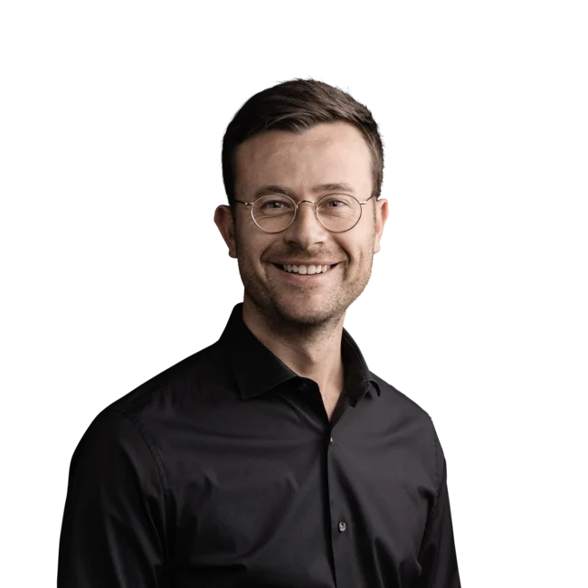 Harald Kager Uomo sorridente con occhiali e camicia nera su sfondo bianco