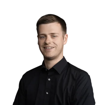 Fabian Tirler | Sales Consultant Lächelnder junger Mann mit kurzen braunen Haaren in schwarzem Hemd vor weißem Hintergrund