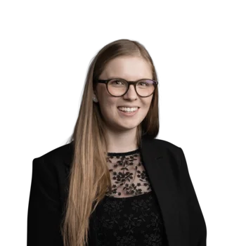 Allison Nardon | Senior Media Planner Junge Frau mit langen Haaren, Brille und schwarzem Spitzenoberteil lächelnd