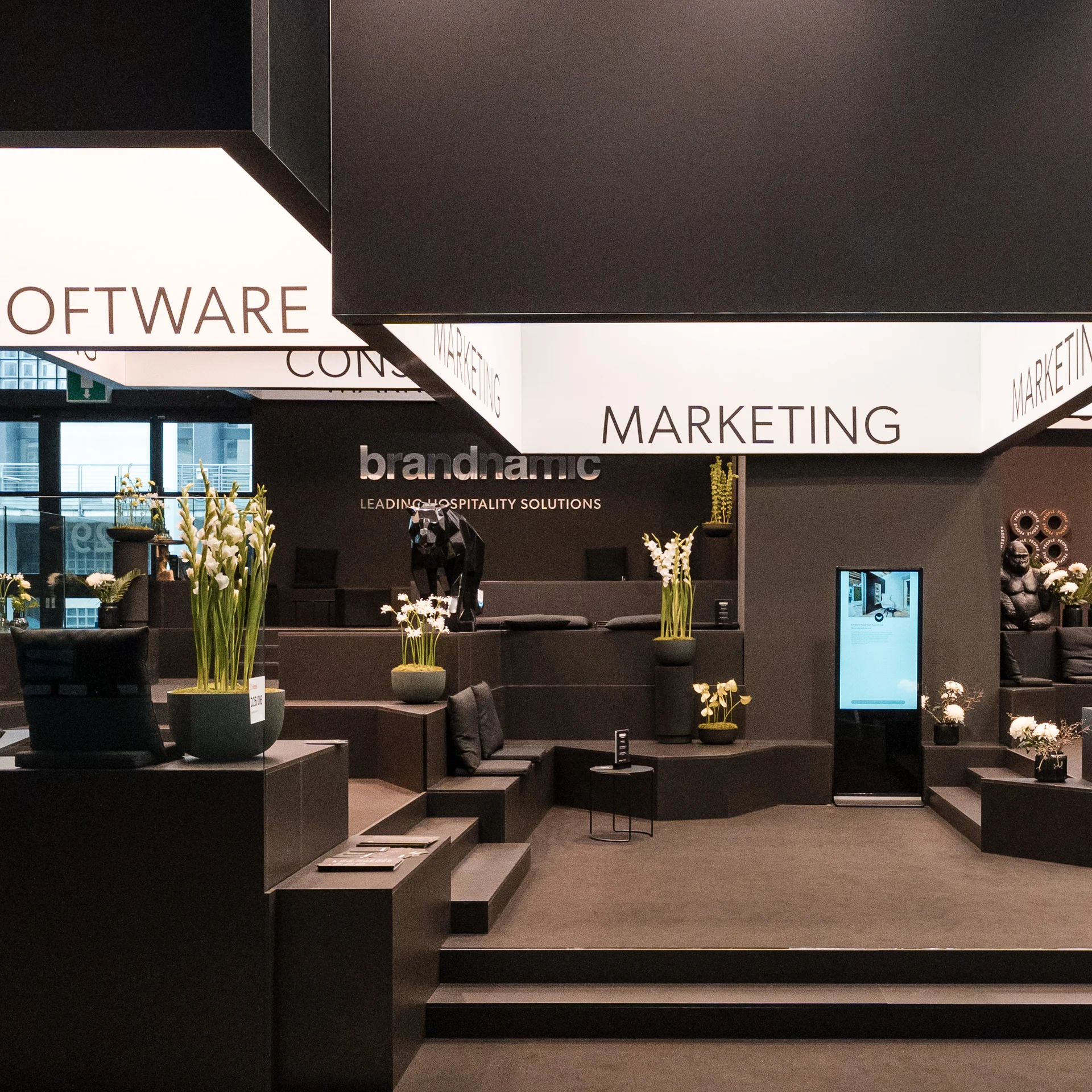 Was wäre Hotelmarketing ohne die passenden Events? Moderner Messestand von brandnamic mit schwarzem Design und beleuchteten Würfeln