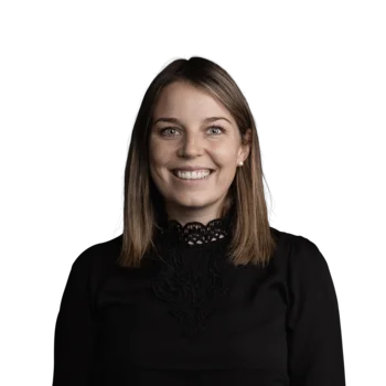 Magdalena Faltner | HR Manager Porträt einer lächelnden Frau mit schwarzer Spitzebluse vor weißem Hintergrund