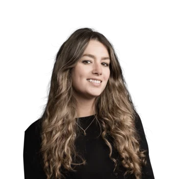 Elena Marin | Corporate Marketing Manager Porträt einer lächelnden jungen Frau mit langen lockigen Haaren vor weißem Hintergrund