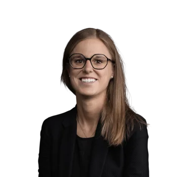 Michaela Kronbichler | Senior Consultant Porträt einer lächelnden Frau mit Brille und schwarzem Blazer vor weißem Hintergrund