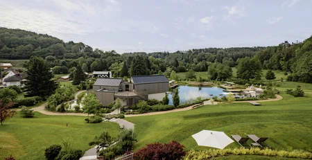 The best references for our hotel marketing Landscape with green fields, pond, buildings, and blue sky with clouds
