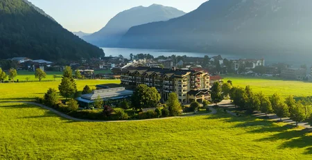 The best references for our hotel marketing Hotel in green valley with mountains and lake in sunlight